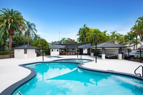 una piscina en un complejo con palmeras en Tranquil Oasis on Pine Lake, en Gold Coast