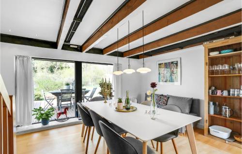 a dining room and living room with a table and chairs at Stunning Apartment In Gudhjem in Gudhjem