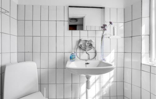 uma casa de banho branca com um lavatório e um espelho em Lovely Apartment In Gudhjem With Kitchen em Gudhjem