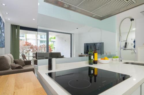 a kitchen with a glass counter top with wine bottles on it at Luxury Avilla Las Olas in Palm-mar