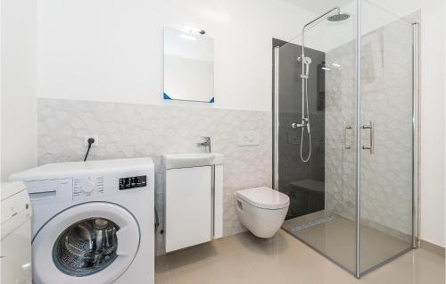 a bathroom with a washing machine and a toilet at Beautiful Home In Skradin-dubravice With 4 Bedrooms, Wifi And Outdoor Swimming Pool in Čulišić
