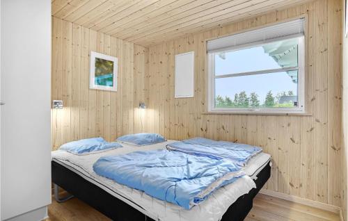 Ce lit se trouve dans une chambre en bois dotée d'une fenêtre. dans l'établissement Lovely Home In Idestrup With Sauna, à Bøtø By
