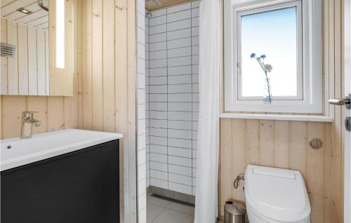 Vester SømarkenにあるBeautiful Home In Nex With 3 Bedrooms, Sauna And Wifiのバスルーム(トイレ、洗面台付)、窓が備わります。