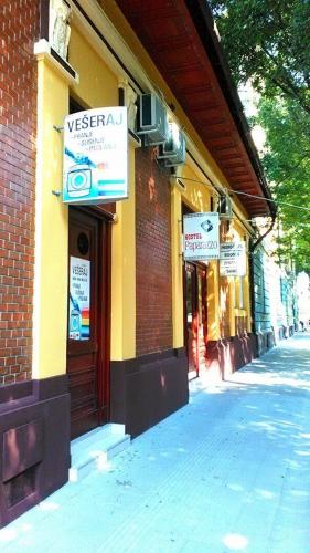 a building with signs on the side of a street at Hostel Paparazzo & Apartmens in Kikinda