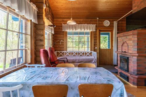ein Esszimmer mit Tisch und Kamin in der Unterkunft Villa Blue beach / Siniranta in Parkano