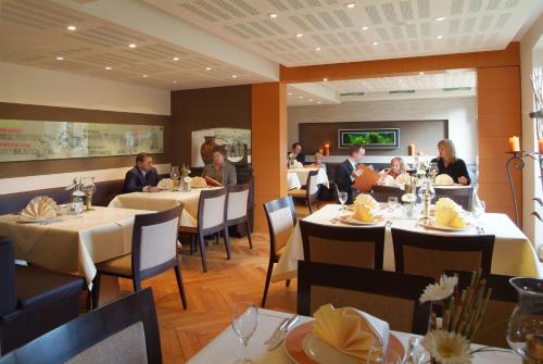 a group of people sitting at tables in a restaurant at Römerhof in Stuttgart