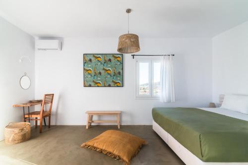 a bedroom with a green bed and a table at Statheros Garden in Antiparos