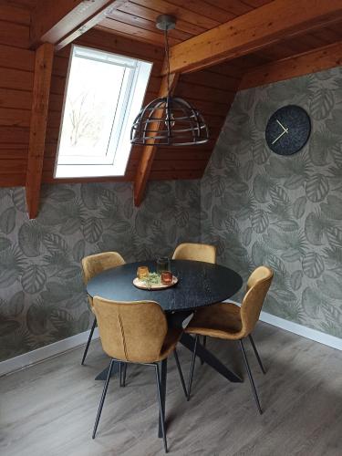 a dining room with a black table and chairs at Bungalow Sud-Harz Bleicherode - boven in Bleicherode