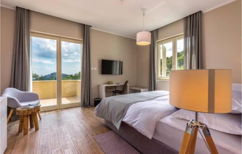a bedroom with a bed and a large window at Awesome Home In Veprinac With 5 Bedrooms, Sauna And Outdoor Swimming Pool in Veprinac