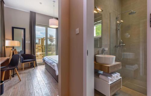 a bathroom with a sink and a shower and a bedroom at Awesome Home In Veprinac With 5 Bedrooms, Sauna And Outdoor Swimming Pool in Veprinac