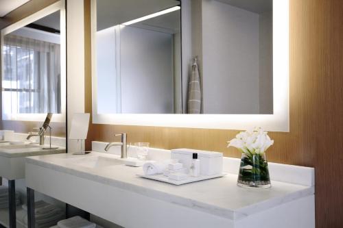 a white sink sitting under a mirror in a bathroom at The Knickerbocker in New York