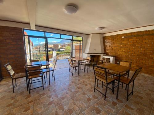 a dining room with tables and chairs and a brick wall at Tupac Huaraz in Huaraz