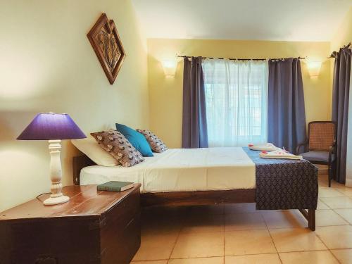 1 dormitorio con 1 cama y 1 mesa con lámpara en Villa Cavelossim, en Cavelossim