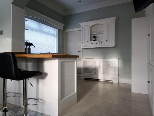 a kitchen with white cabinets and a counter and a window at The Tides in Cleethorpes