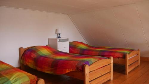 2 camas con mantas de colores en una habitación en Appartement de Voshaar, en Enschede