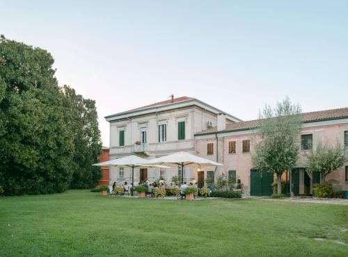 ein großes Haus mit Rasen davor in der Unterkunft Agriturismo Tenuta La Pila in Villa Bartolomea