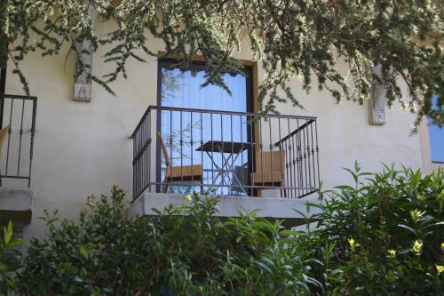 a balcony with chairs and an umbrella in a window at Hotel Bastide & SPA - Villa de Lourmarin in Lourmarin