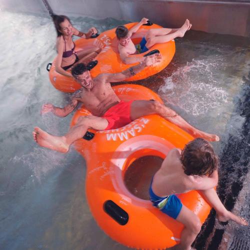 a group of people riding on an orange raft in the water at Dreilandhof in Loipersdorf bei Fürstenfeld