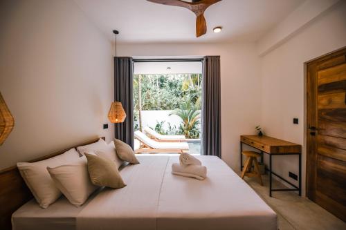 1 dormitorio con 1 cama, ventana y escritorio en Terra Villas, en Ahangama