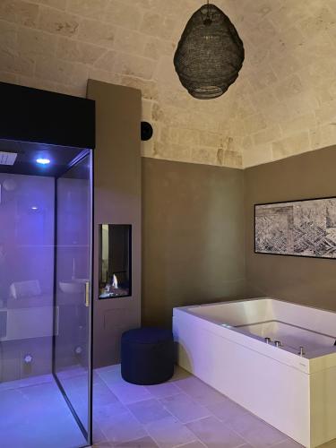 a bathroom with a tub and a glass shower at Dimora Palestro by MANZONI COLLECTION in Monopoli