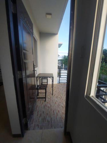 a room with a table and a chair and a window at Snowbird Townhouse Azumi in Dumaguete