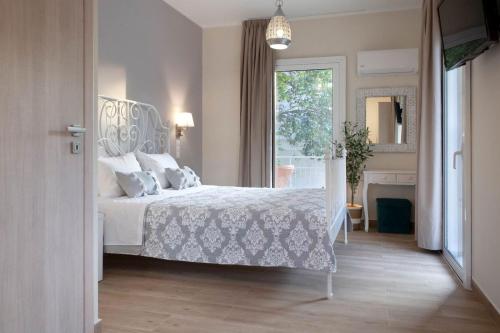 una camera con un letto bianco e una finestra di Lilly Apartments ad Atene
