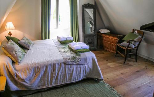 ein Schlafzimmer mit einem Bett mit einem Spiegel und einem Stuhl in der Unterkunft Beautiful Home In La Cassagne With Kitchen in Ladoux