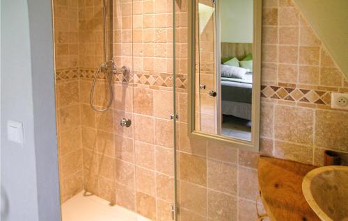 ein Bad mit einer Dusche, einem Waschbecken und einem Spiegel in der Unterkunft Beautiful Home In La Cassagne With Kitchen in Ladoux
