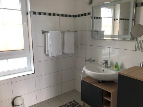 uma casa de banho branca com um lavatório e um espelho em Hus Tina Rügen em Trent