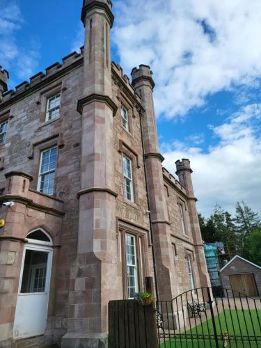 an old brick building with two towers at Langhouse Castle Bed and Breakfast in Inverkip