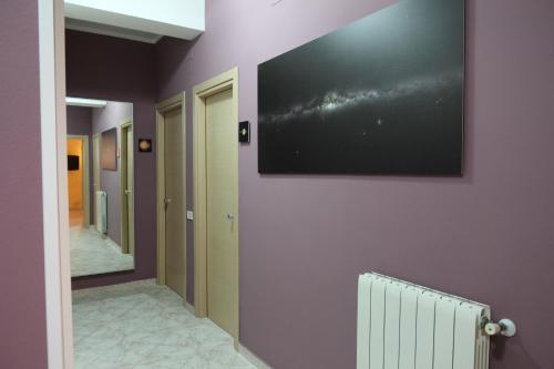 a hallway with a television on a wall at Kosmos in Siracusa