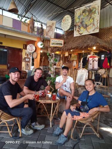 a group of men sitting at a table in a restaurant at Griya Backpacker Pak yon in Malang
