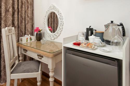 a vanity with a table and a chair next to a table with a mirror at Villa Venusta Luxury Guesthouse - Solar Power in Hermanus