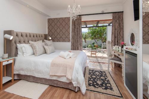 1 dormitorio con 1 cama grande y balcón en Villa Venusta Luxury Guesthouse - Solar Power, en Hermanus