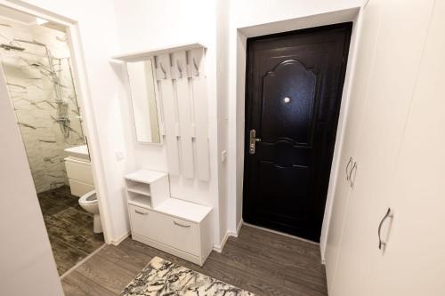 La salle de bains est pourvue de toilettes et d'une porte noire. dans l'établissement New Home Studio, à Zalău