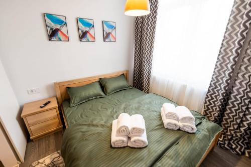 Un dormitorio con una cama con zapatillas. en New Home Studio, en Zalău