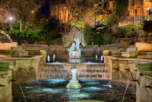 a fountain in the middle of a park at night at La Casa de Tente in Priego de Córdoba
