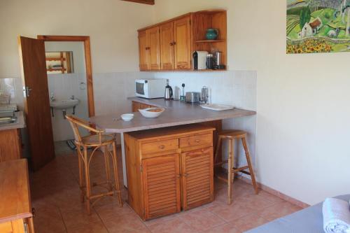 a kitchen with a counter with stools and a counter top at Kusweg Suid 4 in Struisbaai