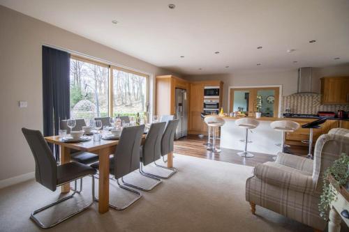 a dining room with a table and chairs and a kitchen at Bradley Manor, Cosy Retreat For Families & Friends in Huddersfield