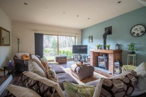 a living room with a couch and a fireplace at Bradley Manor, Cosy Retreat For Families & Friends in Huddersfield