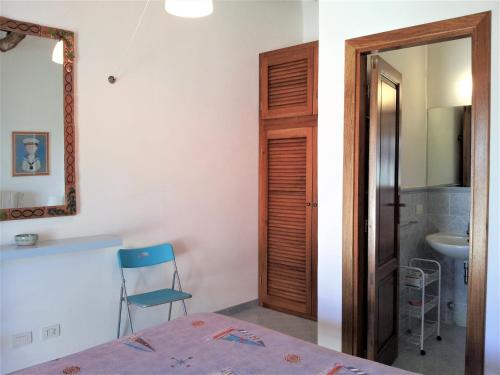 - une chambre avec une table, une chaise et un miroir dans l'établissement Villette Corallo, à Malfa