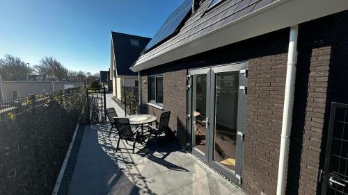 - une terrasse avec une table et des chaises dans un bâtiment dans l'établissement ' Zilten Huus Zoutelande, à Zoutelande