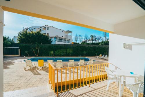 un patio con tavolo, sedie e piscina di Eirasol by Umbral ad Albufeira