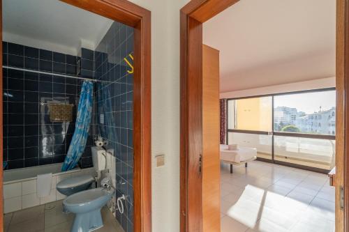bagno con servizi igienici blu e lavandino di Eirasol by Umbral ad Albufeira