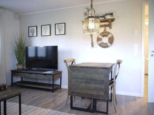 a living room with a tv and a table and a tvictericterictericter at Ocean Hill in Scharbeutz