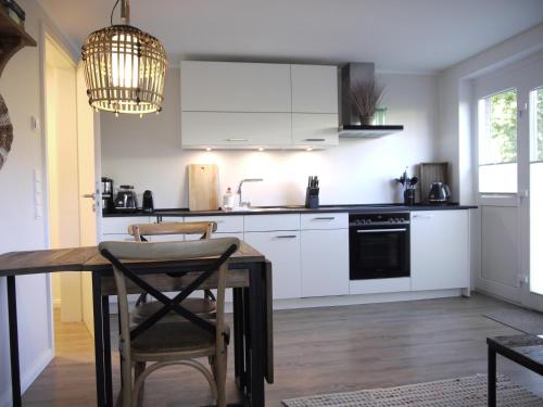 a kitchen with white cabinets and a table with chairs at Ocean Hill in Scharbeutz