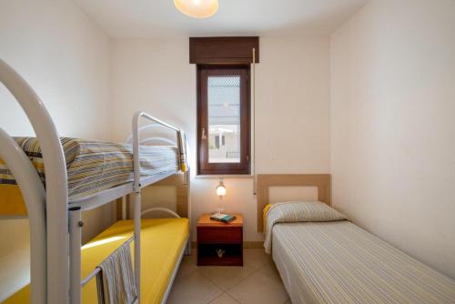 a small room with two bunk beds and a window at Villette Ninfee in Marina di Mancaversa
