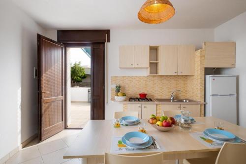 a kitchen with a table with a bowl of fruit on it at Villette Ninfee in Marina di Mancaversa