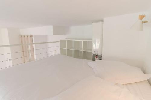 une chambre blanche avec un lit et une fenêtre dans l'établissement Charming studio mezzanine w/ large terrace - Nice, à Nice