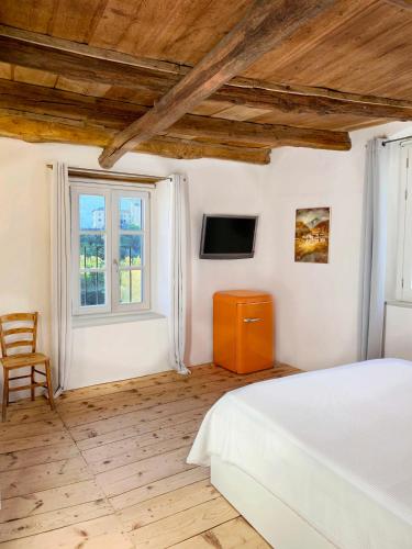 - une chambre avec un lit, une télévision et une fenêtre dans l'établissement Antica Torre, à Sondrio